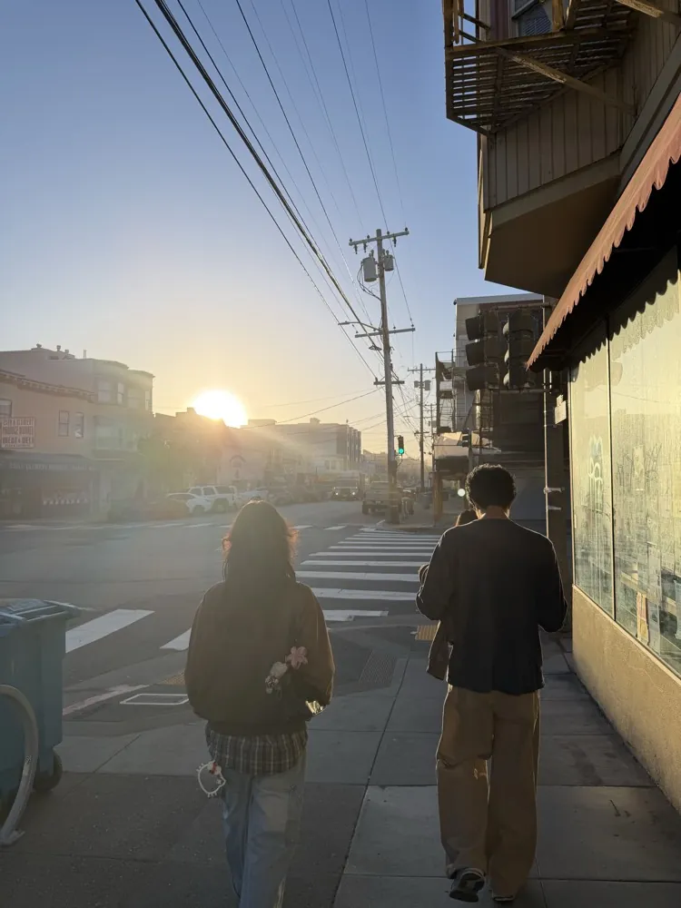 Two friends walking down a street at golden hour