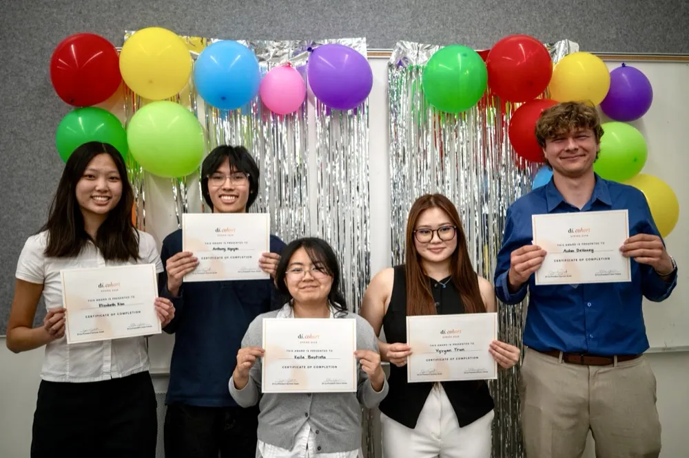Holding certificates in front of balloons