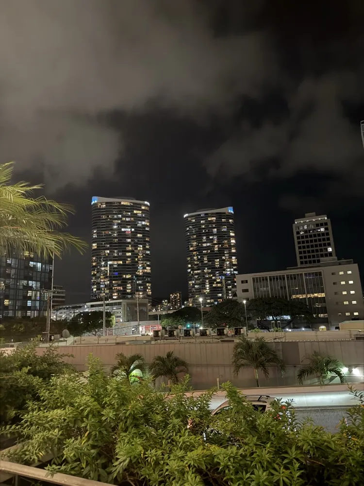 High rise towers at night under a cloudy sky